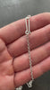 Silver diamond cut cable chain necklace on a textured dark surface