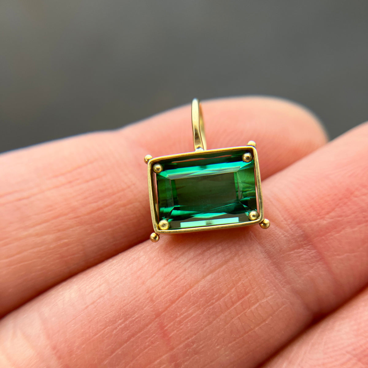 green radiant cut tourmaline pendant in 18k gold