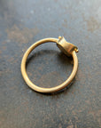Gold ring with a unique design on a textured surface
