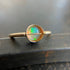 Gold ring with an opal stone on a dark surface