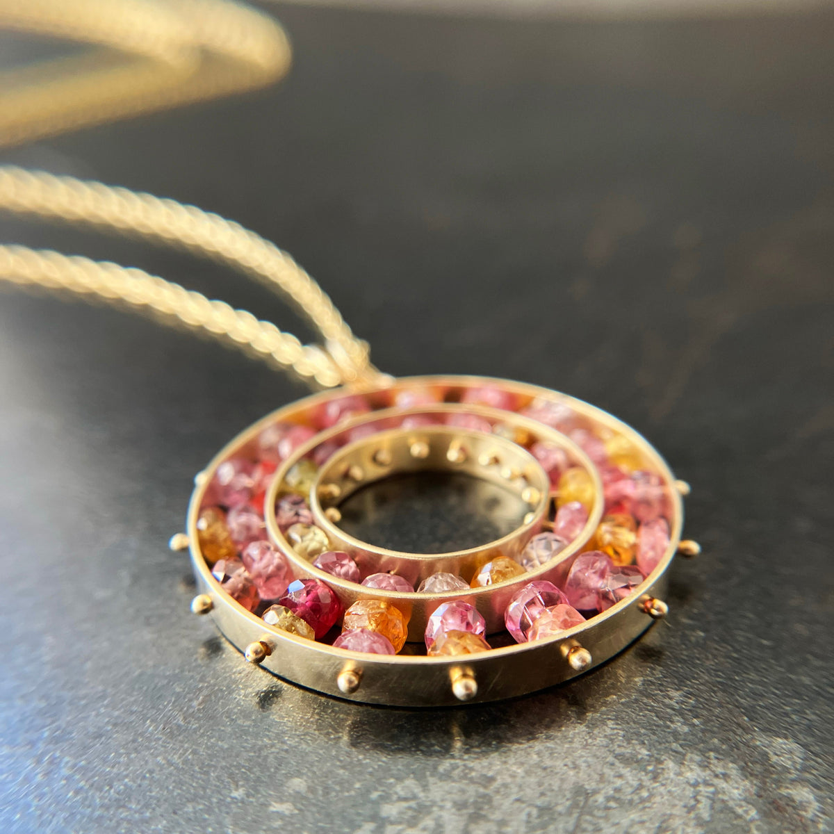 sapphire bead pendant with concentric circles of 14k gold