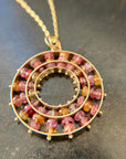 sapphire bead pendant with concentric circles of 14k gold