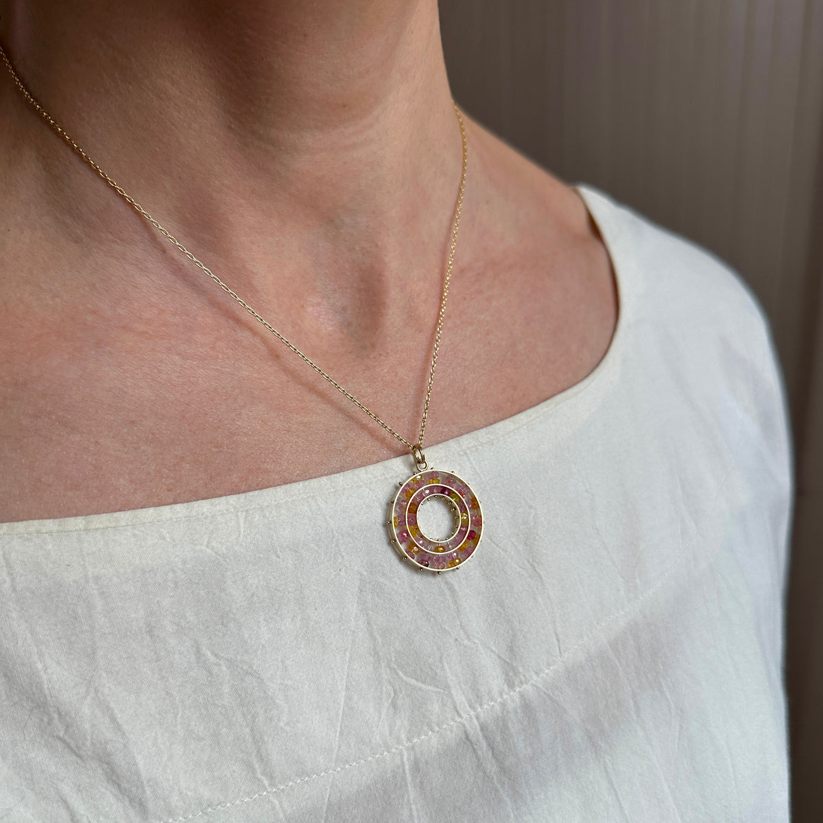 sapphire bead pendant with concentric circles of 14k gold