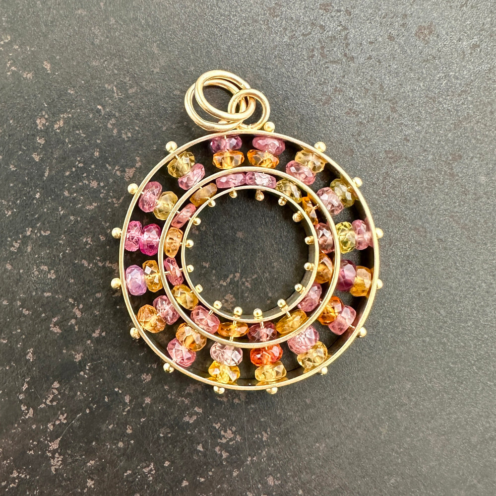 sapphire bead pendant with concentric circles of 14k gold
