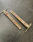 14k Gold bar earrings with colorful sapphire gemstones on a dark surface