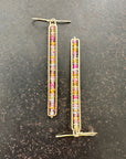 14k Gold bar earrings with colorful sapphire gemstones on a dark surface