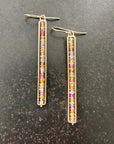 14k Gold bar earrings with colorful sapphire gemstones on a dark surface