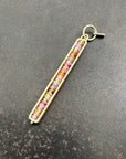 Necklace with a colorful sapphire beaded pendant on a dark surface