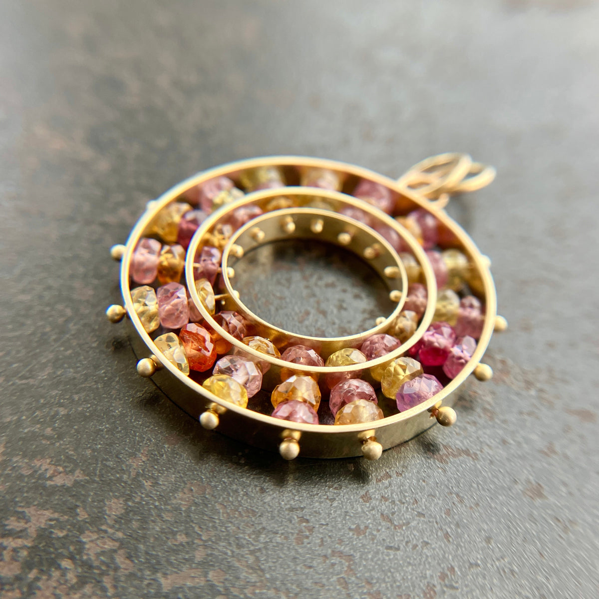 sapphire bead pendant with concentric circles of 14k gold