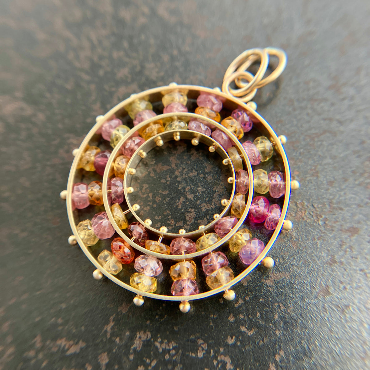 sapphire bead pendant with concentric circles of 14k gold