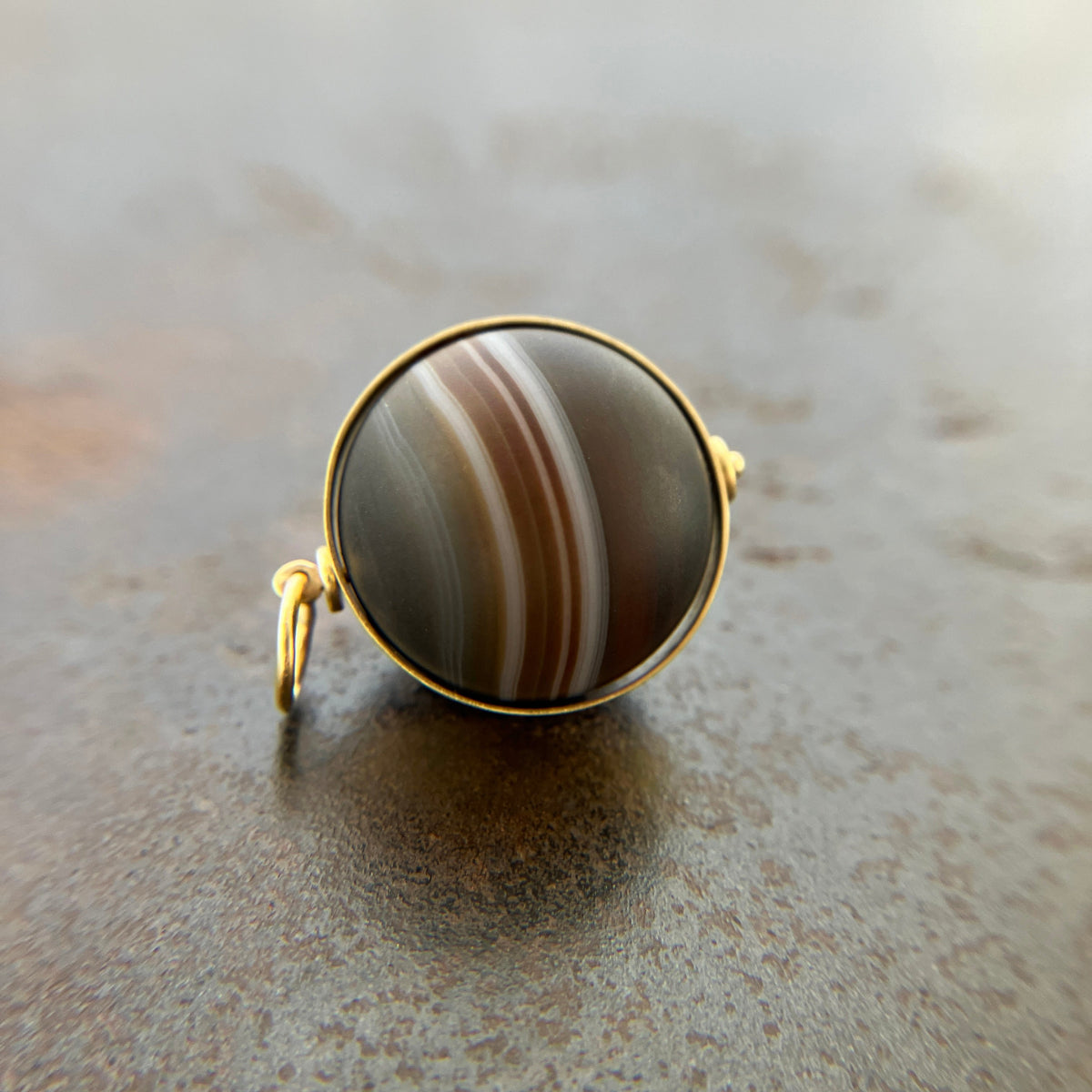 saturn agate orb with bands of color set in 18k gold