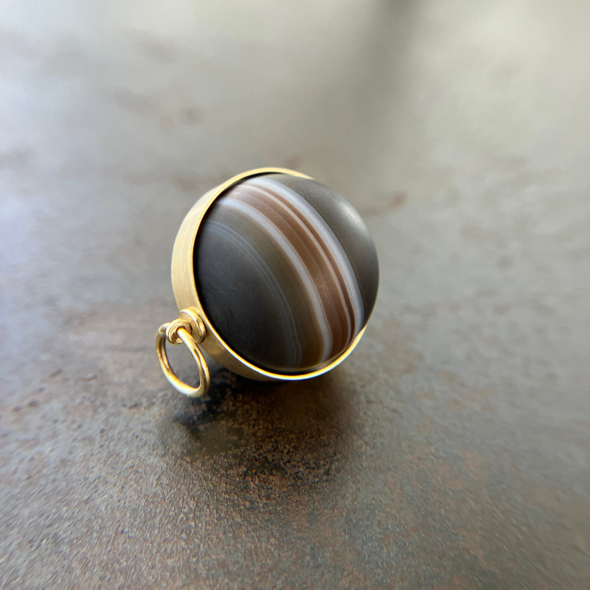 saturn agate orb with bands of color set in 18k gold