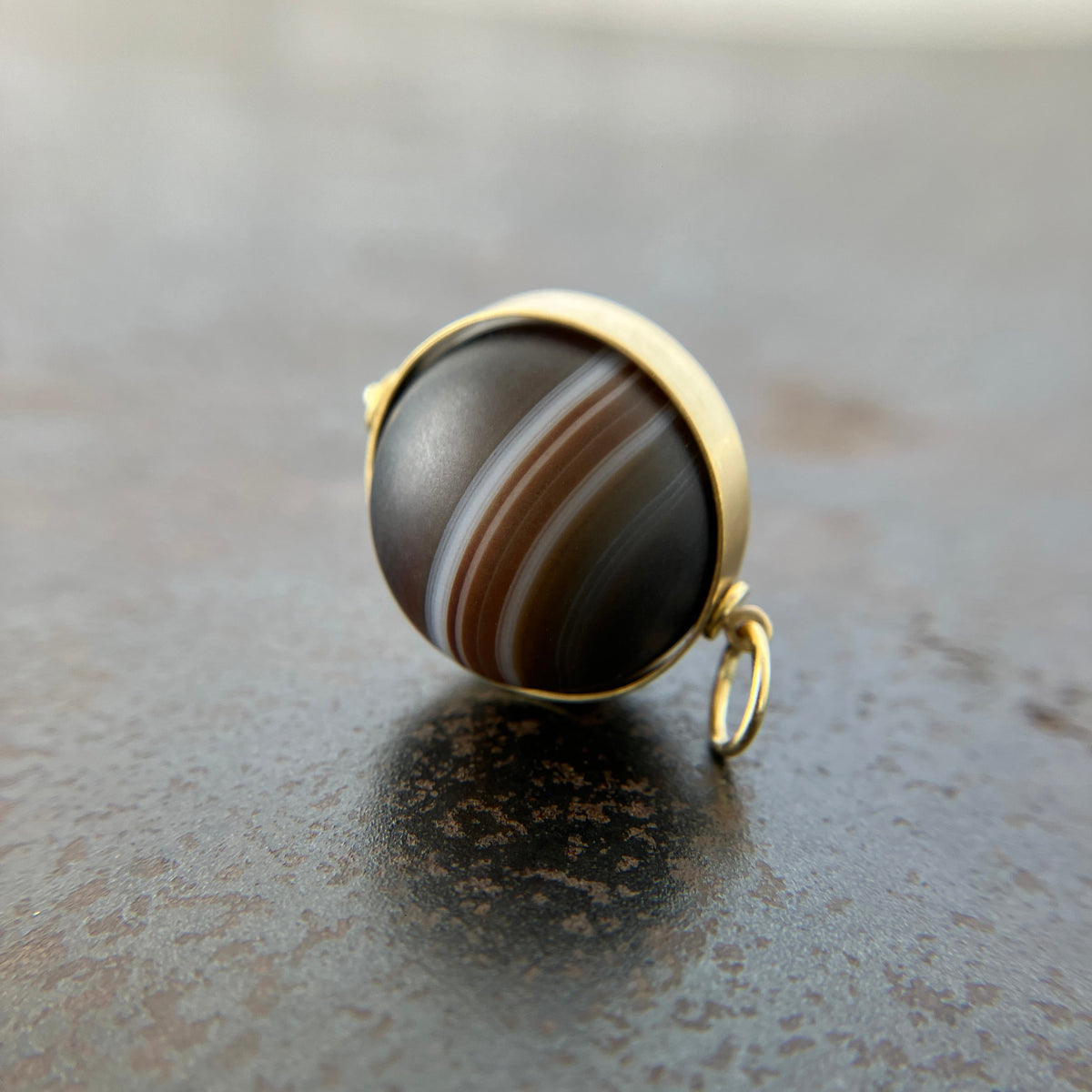 saturn agate orb with bands of color set in 18k gold