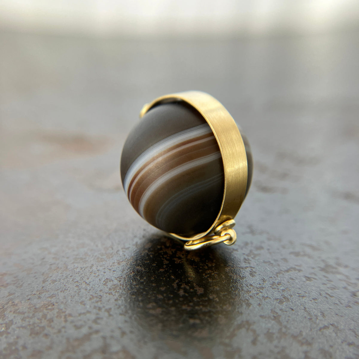 saturn agate orb with bands of color set in 18k gold