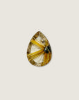 A teardrop-shaped gemstone featuring a striking golden-yellow and cream radial pattern with a small dark inclusions, centered on a solid light beige background.