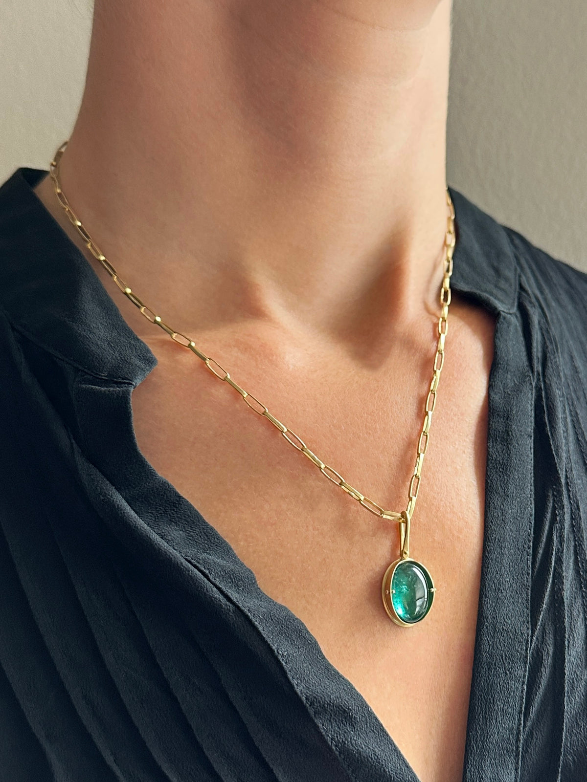 teal green tourmaline oval pendant in 18k gold on a model