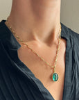 teal green tourmaline oval pendant in 18k gold on a model