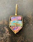 A shield-shaped pendant featuring an 18k gold frame and three rectangular inlay wood replacement opals in pink, turquoise, purple, and brown.