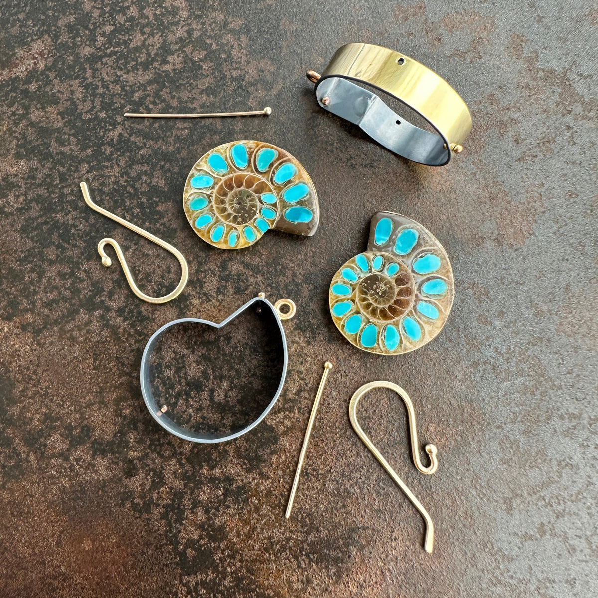 process photo of ammonite with embedded turquoise earrings in silver and gold on gold hooks