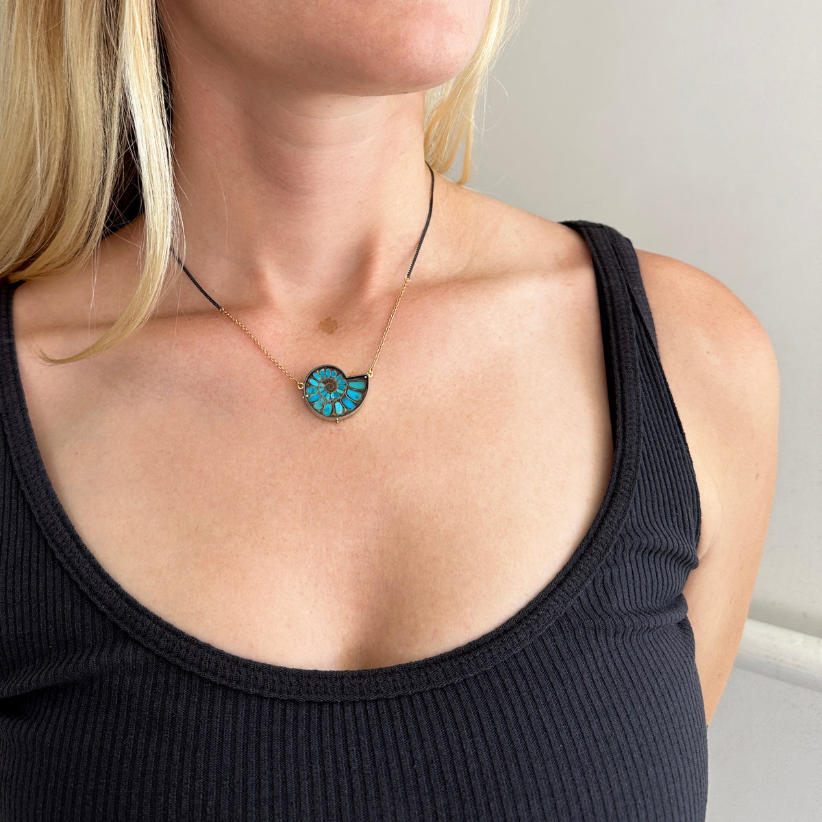 model wearing ammonite with embedded turquoise necklace in silver and gold on silver and gold chain