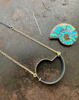 process photo of ammonite with embedded turquoise necklace in silver and gold on silver and gold chain